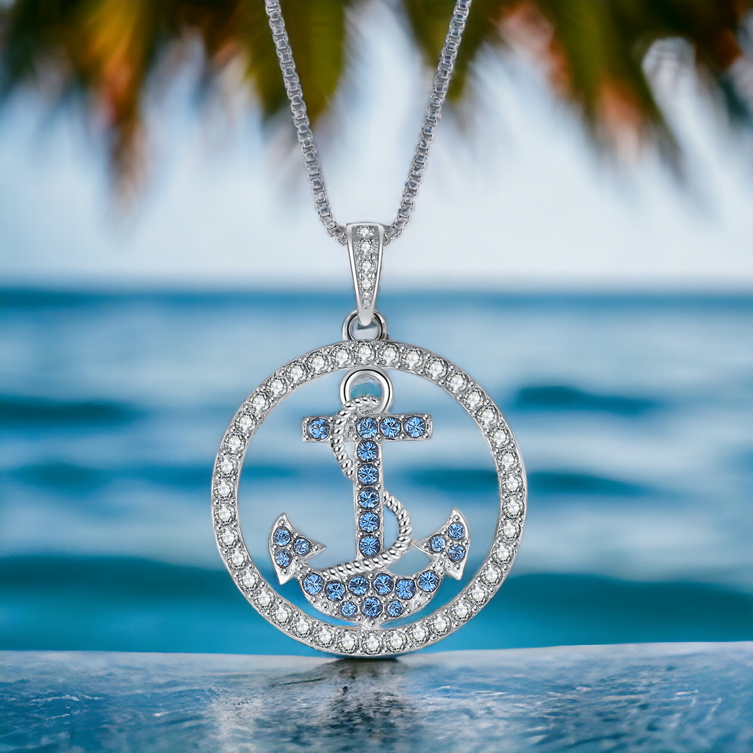 Ankerkette aus 925er Silber vor dem Meer – blauer Anker mit funkelnden Zirkonia, Symbol fuer Liebe, Halt und Vertrauen