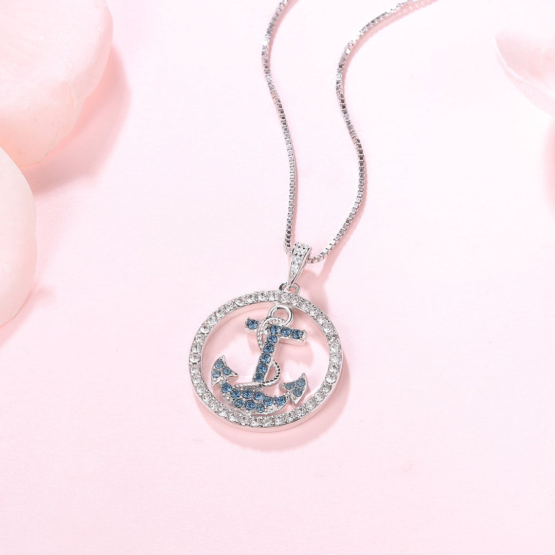 Zarte Ankerkette mit blauen 5A Zirkonia auf rosa Hintergrund – hochwertiger Silberschmuck mit Bedeutung fuer Vertrauen und Liebe