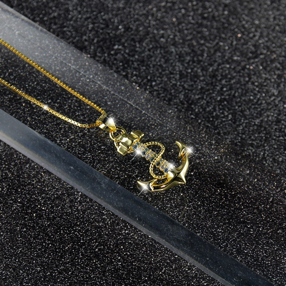 Goldene Ankerkette auf schwarzem Untergrund – moderner maritimer Schmuck fuer Damen mit Bedeutung und Zirkonia