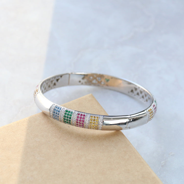 Armreif Rainbow aus Sterlingsilber mit mehrfarbigen Zirkonia, elegant platziert auf einer Schmuckverpackung – perfekte Geschenkidee