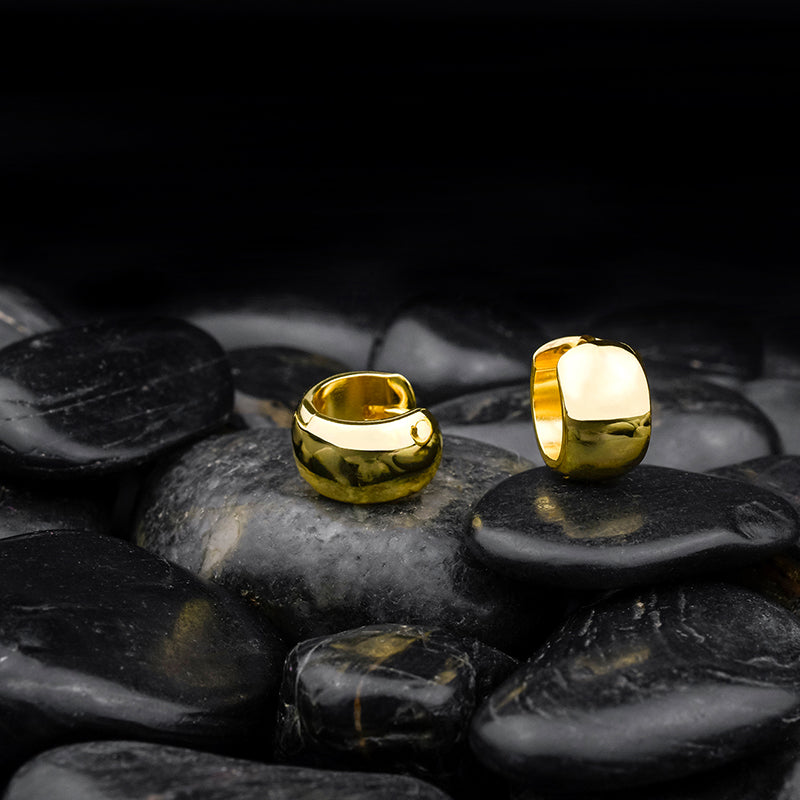 Creole Bright Gold – elegante, vergoldete Ohrringe aus 925 Sterling Silber stilvoll inszeniert auf schwarzen Steinen, edler Damenschmuck mit Hochglanz-Finish.