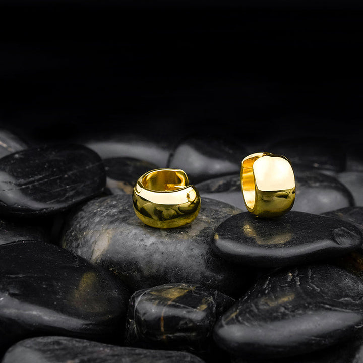 Creole Bright Gold – elegante, vergoldete Ohrringe aus 925 Sterling Silber stilvoll inszeniert auf schwarzen Steinen, edler Damenschmuck mit Hochglanz-Finish.