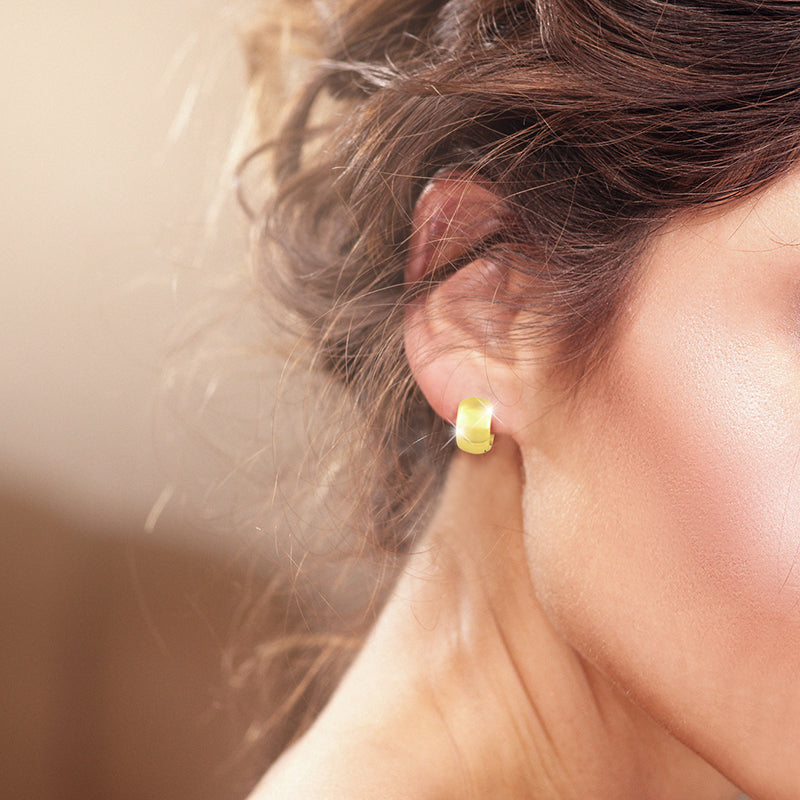 Model trägt Creole Bright Gold – elegante, breite vergoldete Creolen aus 925 Sterling Silber als stilvoller Ohrschmuck für Damen.
