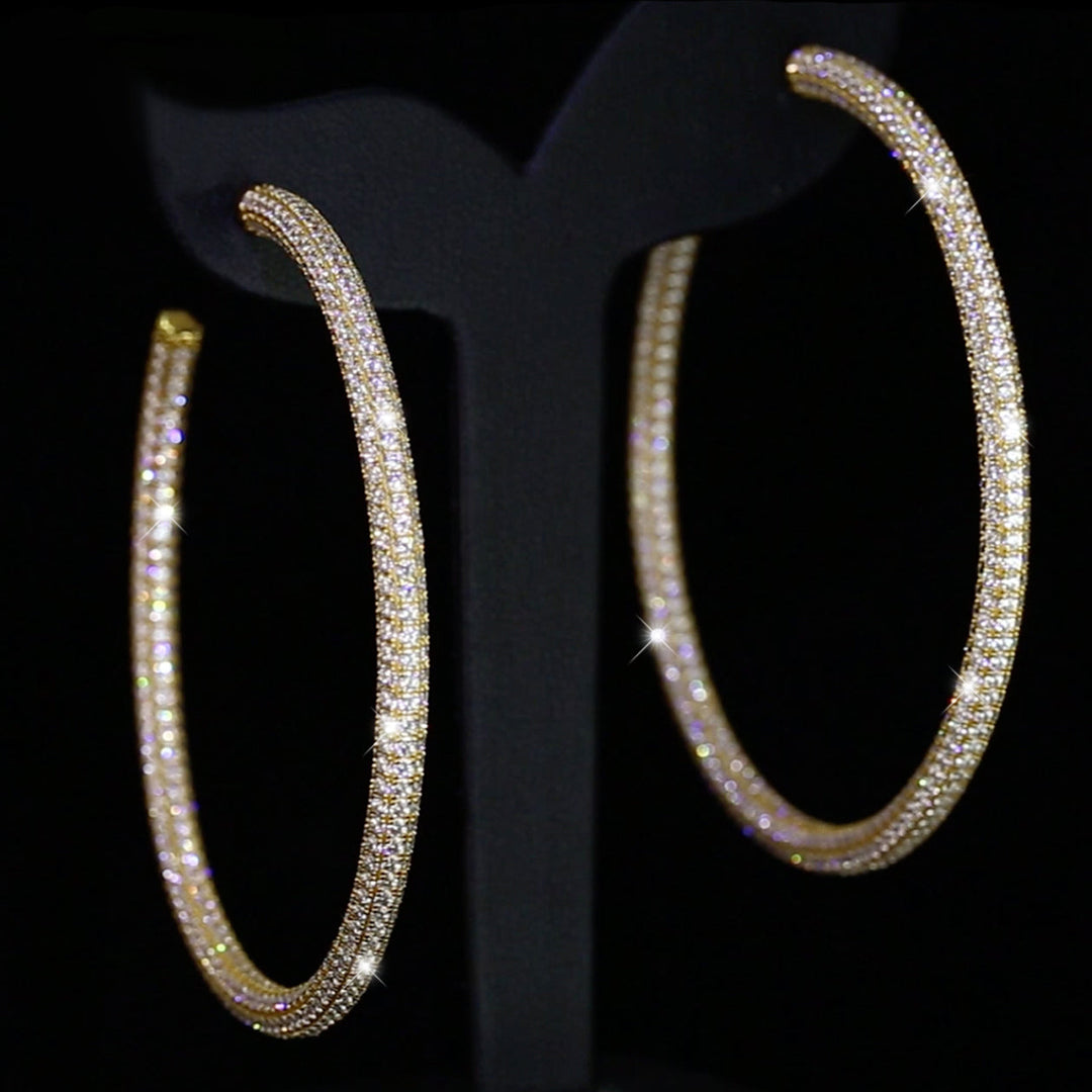 Glänzende Creole Sparkly Elegance Gold auf schwarzem Display – luxuriöse Hoop-Ohrringe mit Zirkonia-Steinen