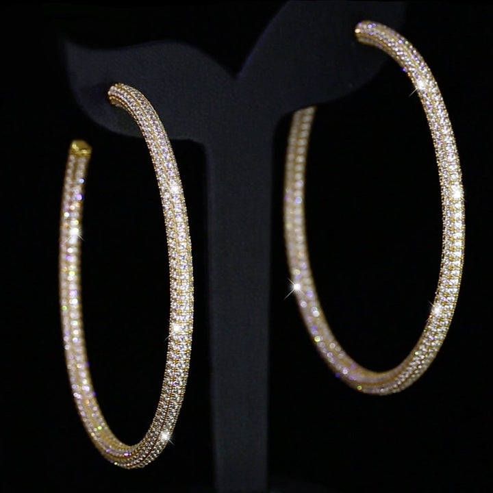Glänzende Creole Sparkly Elegance Gold auf schwarzem Display – luxuriöse Hoop-Ohrringe mit Zirkonia-Steinen