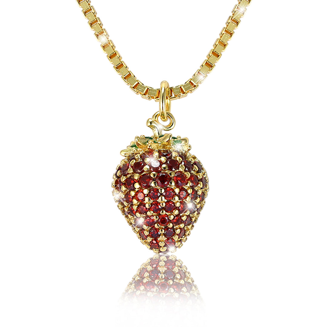 Nahaufnahme der vergoldeten Erdbeer-Halskette aus 925 Sterlingsilber mit roten und grünen 5A Zirkonia, funkelnder Frucht-Anhänger als edler Damenschmuck.