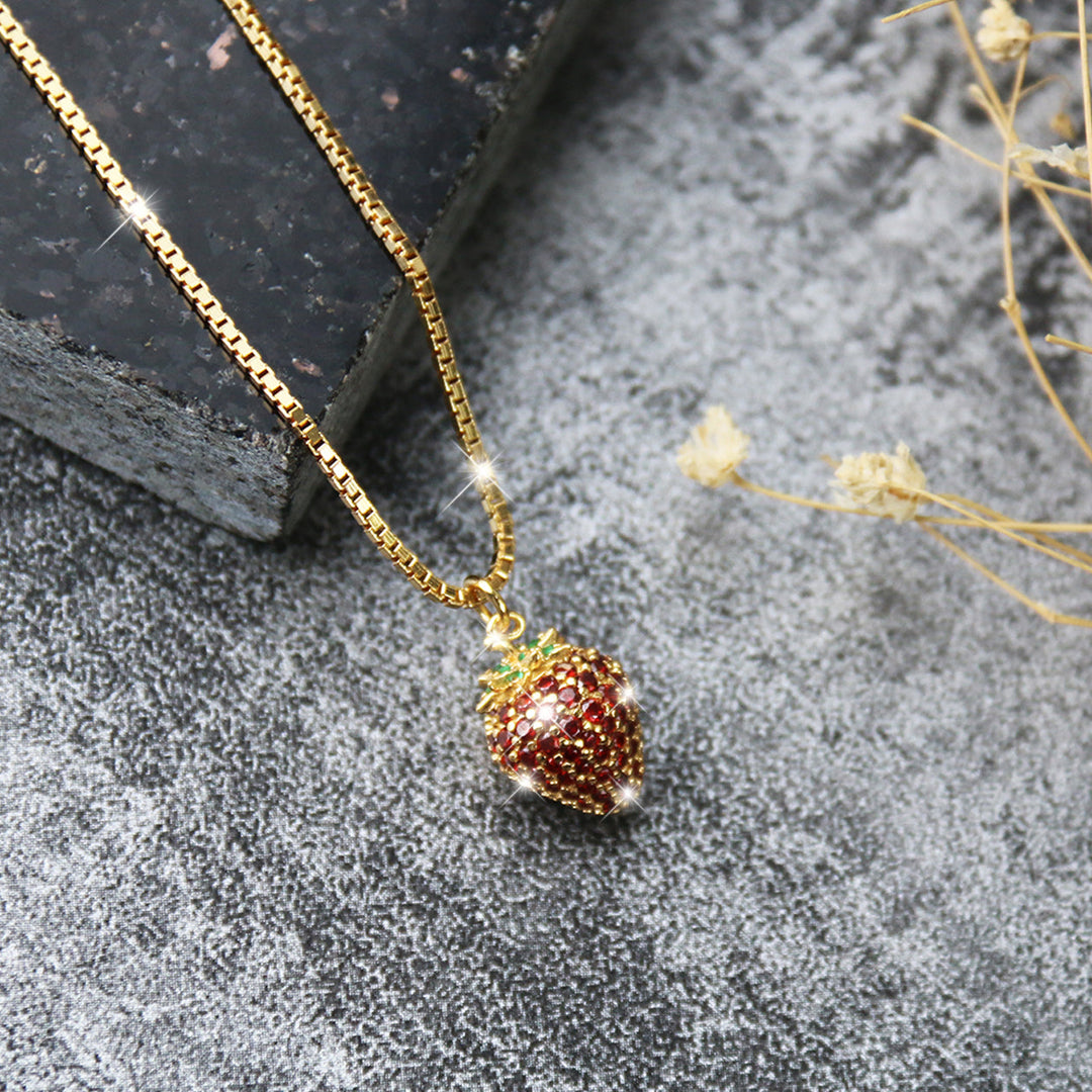 Elegante Erdbeerkette aus vergoldetem 925 Sterlingsilber mit glänzenden 5A Zirkonia auf dunklem Hintergrund – luxuriöses Schmuckstück im Frucht-Design.