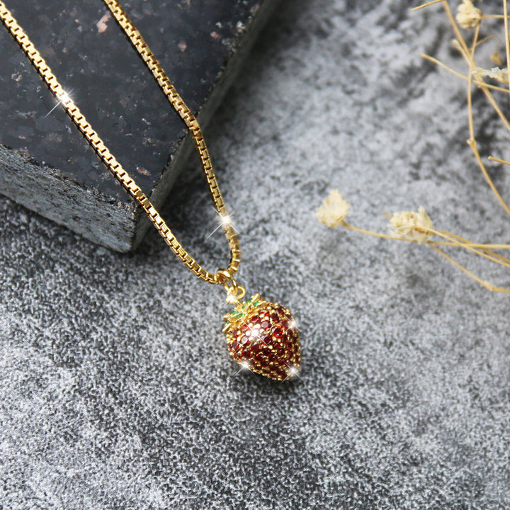 Elegante Erdbeerkette aus vergoldetem 925 Sterlingsilber mit glänzenden 5A Zirkonia auf dunklem Hintergrund – luxuriöses Schmuckstück im Frucht-Design.