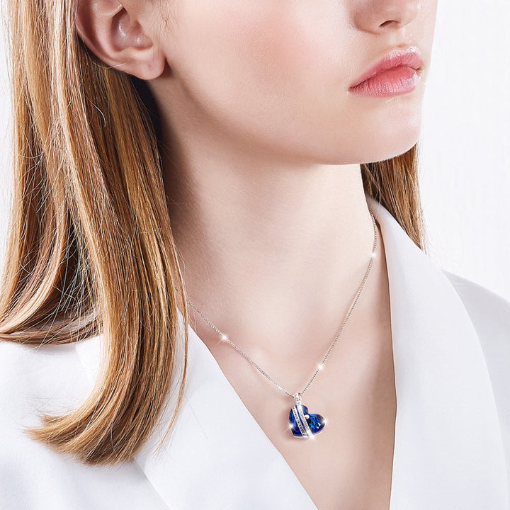 Halskette „Für immer und ewig“ mit blauem Herzanhänger, getragen von einem Modell – stilvoller Silberschmuck.