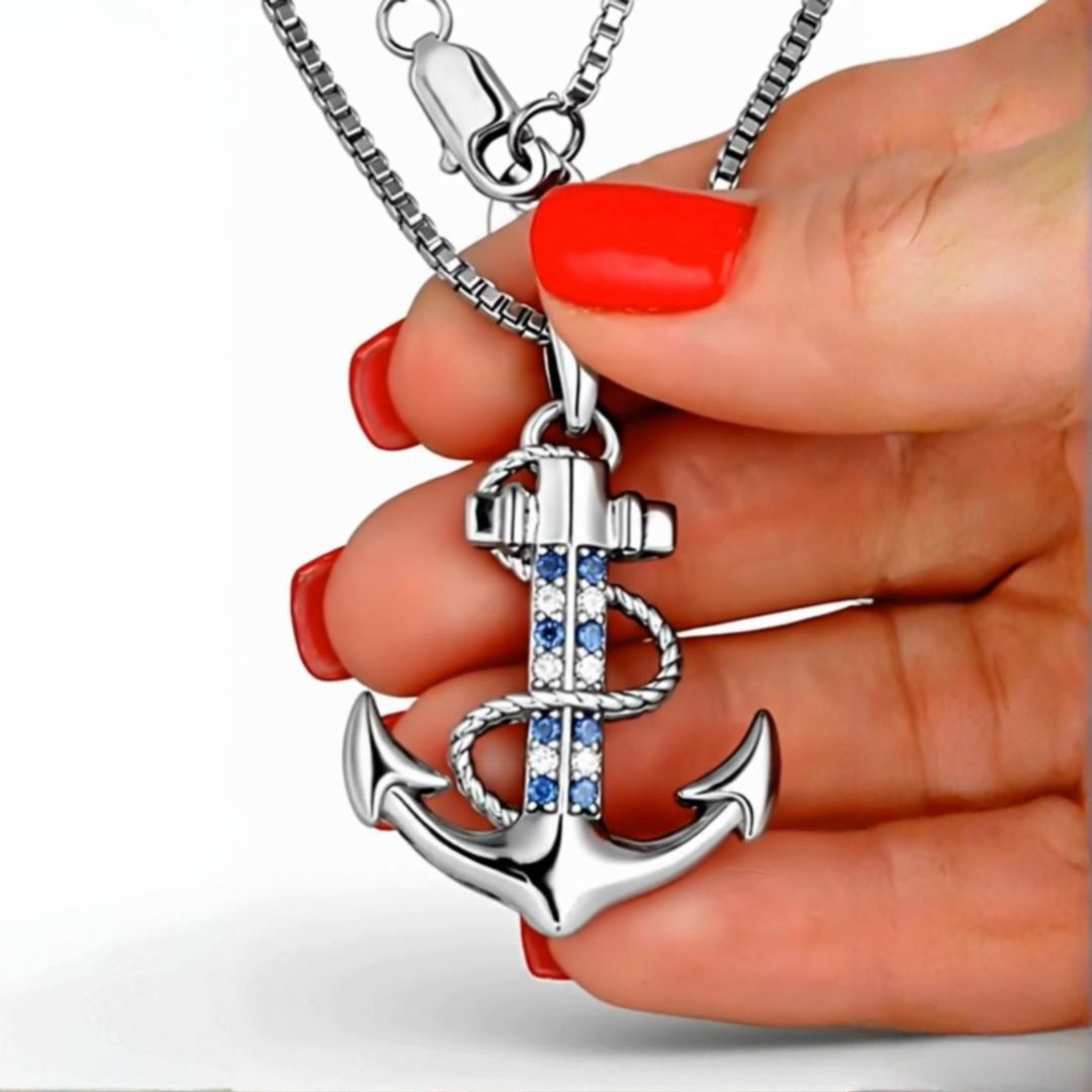 Silberne Anker-Halskette mit blauen Zirkonia-Steinen von PAVELS, gehalten in einer Hand 
